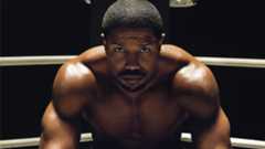 Michael B. Jordan as Adonis Creed, sitting in the corner of a boxing ring