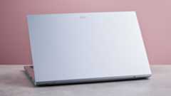 Three-quarter view of rear of Acer Aspire Go 15 open on desk, with pink wall in background