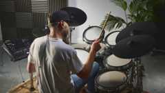 Man playing Roland TD716 electronic drum set in a studio