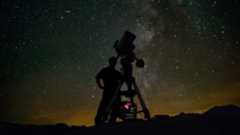 Astronomer using telescope to observe the night sky