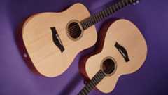 Two Taylor beginner acoustic guitars lying on a purple floor