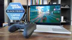 Asus ROG Zephyrus G14 on table with Xbox controller with Tom's Guide Black Friday Laptop Deals badge