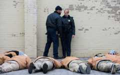 guards talk while prisoners lie on the ground in orange is the new black