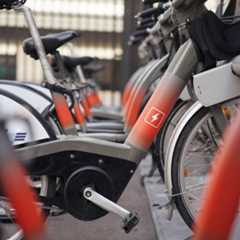 A row of e-bikes in a bike rack with the power symbol on the frame