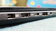 A black ASUS ProArt P16 laptop on a green sofa