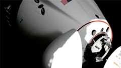 a space capsule is seen docking to a space station in a close-up of its nose section