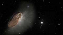 A large rocky comet floats in the darkness of space with some stars in the distance.