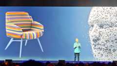 AU 2025; a man on a stage with a model of a chair