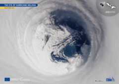 A photo of a hurricane from space, showing spots of blue ocean beneath heavily swirling white clouds