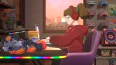 A young woman types at a laptop on her desk while a puppy with a pentagram on its head sleeps nearby