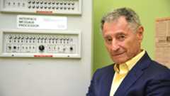 Dr. Leonard Kleinrock poses beside the first Interface Message Processor