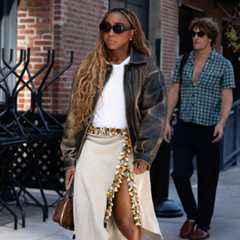 a woman at new york fashion week wearing a statement midi skirt white tshirt and leather jacket