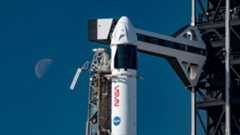 a white and black rocket with NASA markings on it stands poised on a launch pad awaiting its day to launch