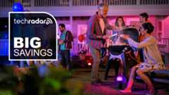 People enjoying a party illuminated by Philips Hue smart lights, with the words &#039;TechRadar Big Savings&#039; overlaid