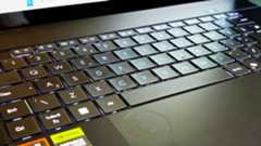 A black ASUS ProArt P16 laptop on a green sofa