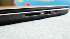 A black ASUS ProArt P16 laptop on a green sofa