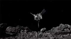 A rendering of a silver spacecraft with two solar panel wings (spacecraft looks like a cube) above a rocky grayish surface.