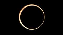 A photo of the moon's silhouette surrounded by the outer edge of the sun in a black sky during a total solar eclipse.
