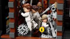 The interior of a circular space station with several floors and rooms filled with minifigures shows the minifigures posed in action.