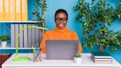 Woman using a laptop in a bright blue office 