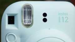 Instax Mini 12 on a brick wall in front of graffiti