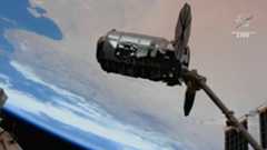 cygnus spacecraft with solar wings visible against the earth. the nasa logo is in the corner