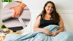 A woman with a bigger build sits up in bed smiling. To the left, an insert showing a close up of a hand holding the corner of a thin mattress or thick mattress topper