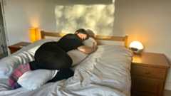 The Tom's Guide Sleep Features Editor lying on her side while using the Yana 360 Body Pillow