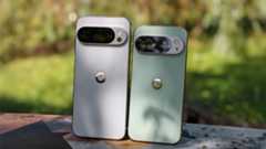 The backs of the porcelain Google Pixel 10 Pro XL and the jade Google Pixel 10 Pro standing next to each other on a bench
