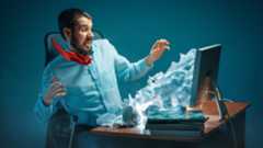 A man shocked by papers pouring out of his computer screen.