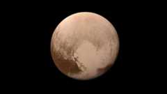 A brownish planet with a heart shaped lighter area toward the bottom right.