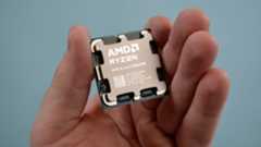 An AMD Ryzen 7 9800X3D in a masculine hand