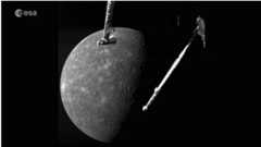 A shaded grey planet hangs in black space with the arms of a spacecraft hanging in the foreground.