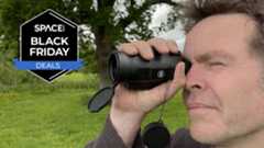 A man looking through a Bushnell Legend 10x42 monocular with grass and trees in the background with a black Space.com Black Friday deals badge in the upper left corner.