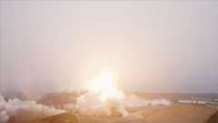 A rocket lifts into a fog layer blanketing its launch site, obscuring the view of the booster.
