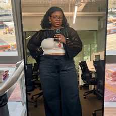 chichi wears black jeans, off white tank top, black crochet bolero while taking a mirror selfie