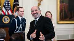 Howard Lutnick giving the double finger gun gesture.