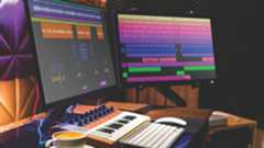 A home music studio with MIDI keyboard, Mac, and dual screens showing a DAW