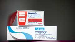 A white and red box of ozempic stacked on top of a white and blue box of wegovy