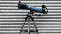A side profile view of the telescope against a corrugated iron backdrop