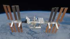 An image of the International Space Station, with its many solar panels and modules, floating above Earth in space