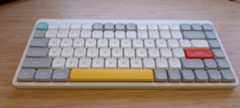 A white NuPhy Air75 V2 keyboard on a wooden desk