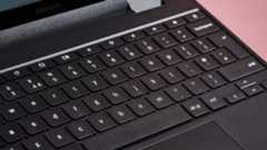 Close-up of keyboard on Samsung Galaxy Chromebook 2 360, open on desk with pink background