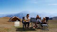 Lifestyle image showing family using a Bluetti power station while camping outdoors