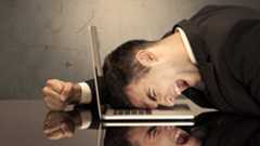 Angry business man screaming on laptop