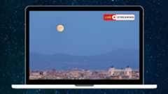 a graphic of a laptop screen with an image of a full moon rising over an Italian city with the words live streaming written in the top right corner.