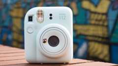 Instax Mini 12 on a brick wall in front of graffiti