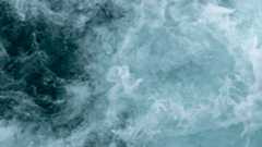 A swirl of blue and white shows ocean waves roiling in the water