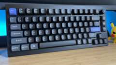 Keychron Q1 HE 8K gaming keyboard on a wooden desk with blue backlighting