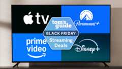 A TV on a stand displaying logos for Apple TV, Paramount Plus, Prime Video and Disney Plus around a Tom&#039;s Guide Black Friday streaming deals badge